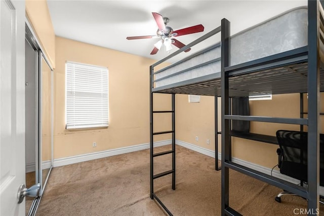 unfurnished bedroom with light colored carpet, ceiling fan, and a closet