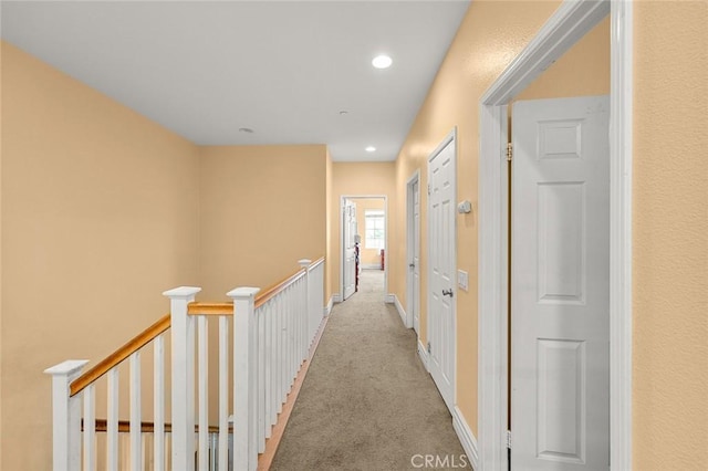 hallway featuring light colored carpet