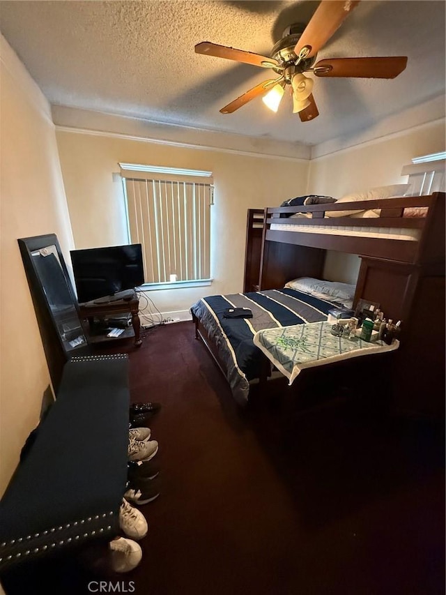 bedroom with ceiling fan, ornamental molding, carpet, and a textured ceiling