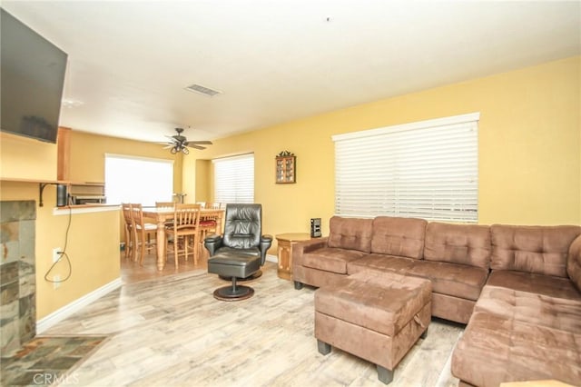 living room with light hardwood / wood-style flooring and ceiling fan