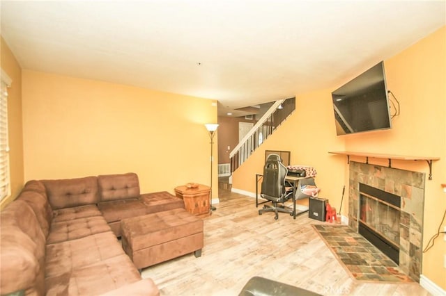 living room featuring hardwood / wood-style flooring and a tiled fireplace