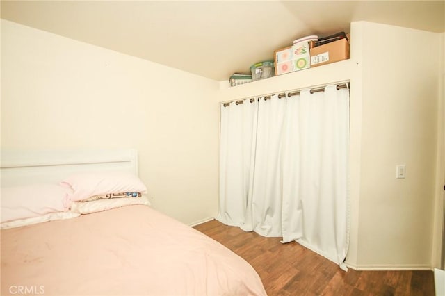 bedroom featuring lofted ceiling and dark wood-type flooring