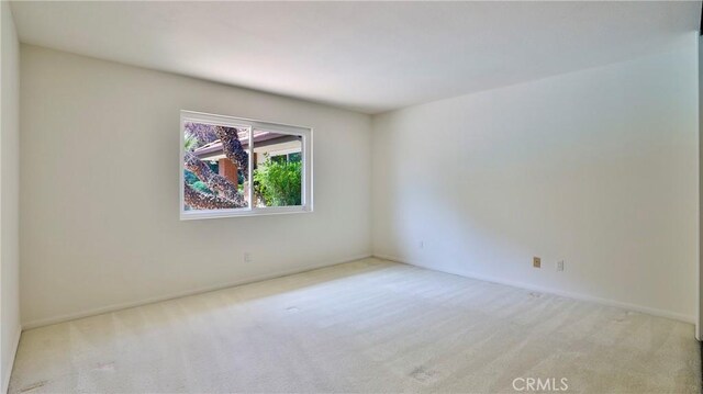 unfurnished room featuring light colored carpet