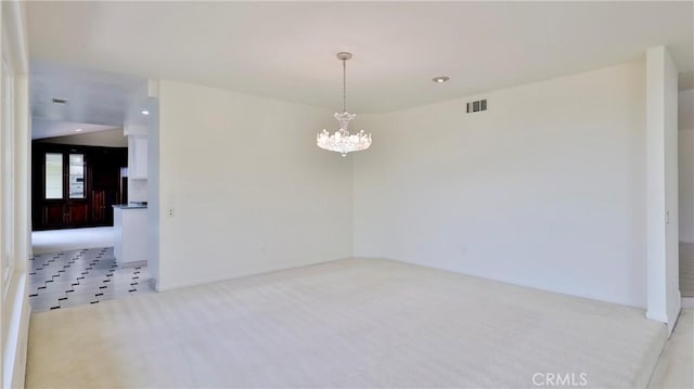 empty room featuring light carpet, an inviting chandelier, and visible vents