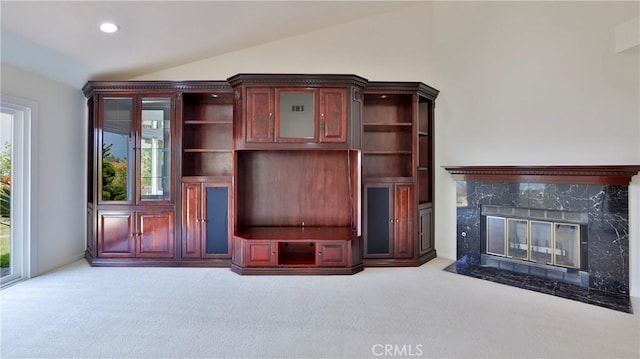 unfurnished living room featuring lofted ceiling, carpet flooring, a high end fireplace, and recessed lighting