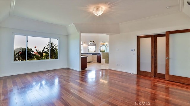 unfurnished living room featuring baseboards and wood finished floors