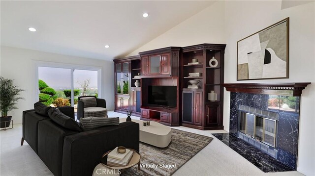 carpeted living room featuring vaulted ceiling and a premium fireplace