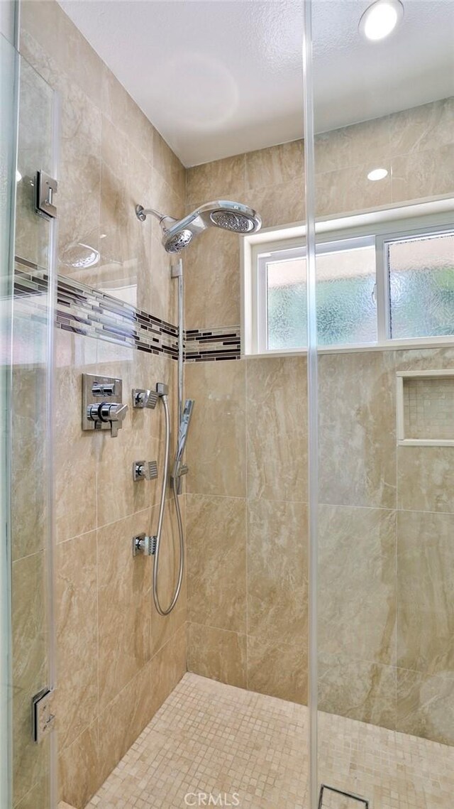 bathroom with a shower with door