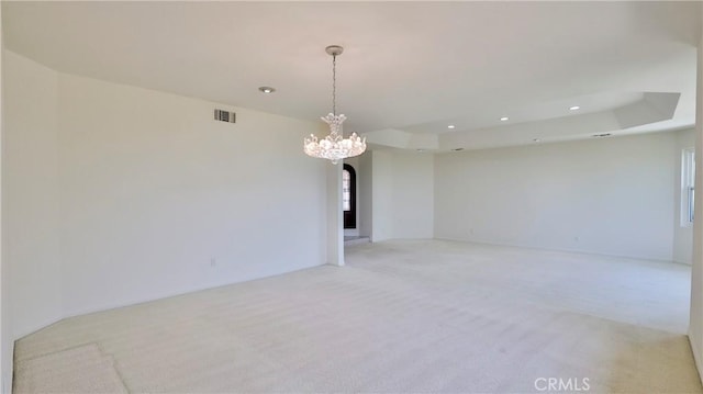 unfurnished room with arched walkways, a tray ceiling, recessed lighting, visible vents, and light carpet