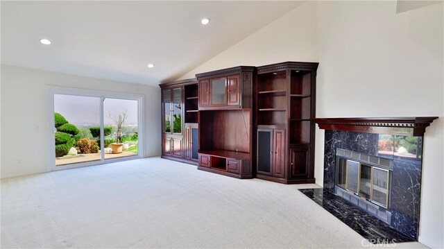 carpeted living room featuring vaulted ceiling and a premium fireplace