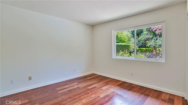 unfurnished room with wood finished floors and baseboards