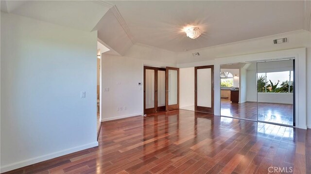 interior space with crown molding, dark wood-type flooring, and french doors