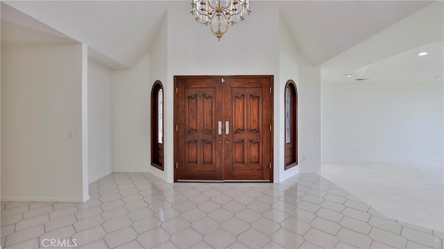 entryway featuring a notable chandelier, tile patterned flooring, a towering ceiling, and recessed lighting