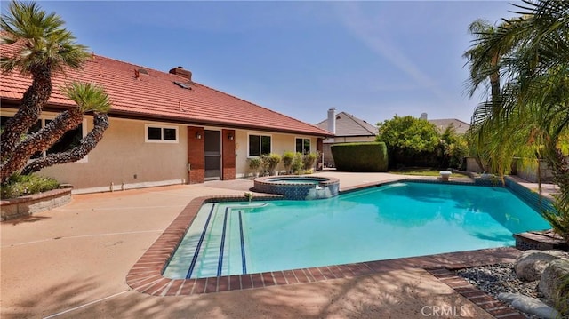 view of swimming pool with a pool with connected hot tub, a patio, and fence