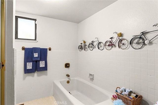 bathroom featuring tile walls and a tub