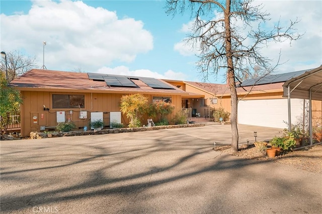 single story home featuring a garage and solar panels