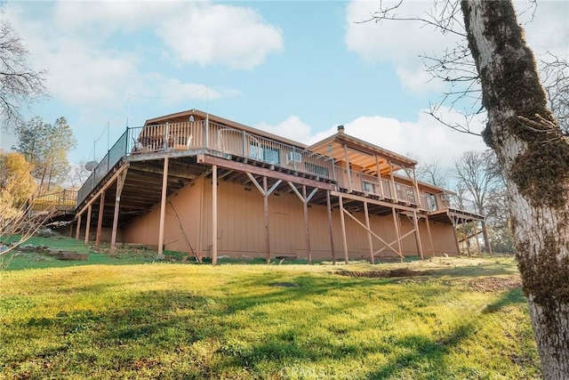 rear view of property featuring a wooden deck and a lawn