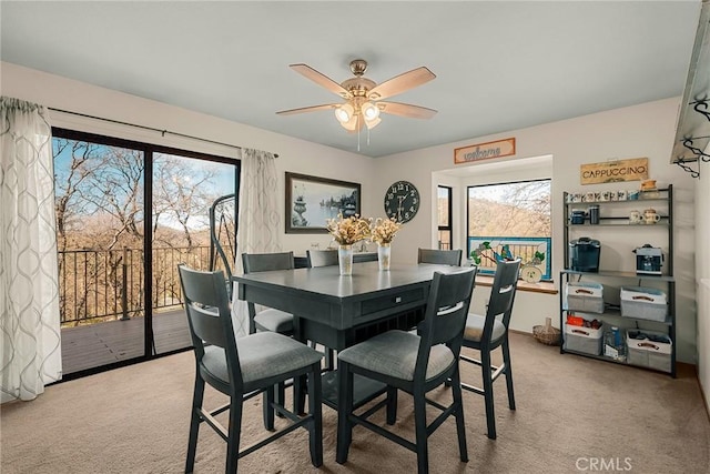 carpeted dining room featuring ceiling fan