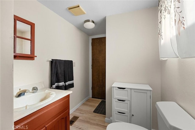 bathroom with vanity, hardwood / wood-style flooring, and toilet