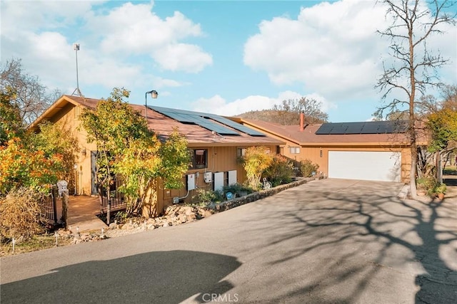 view of front of home with a garage and solar panels