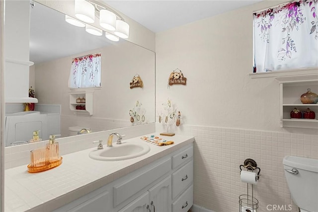 bathroom with vanity, tile walls, and toilet