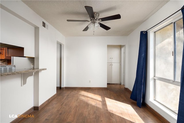 interior space with ceiling fan, dark hardwood / wood-style floors, and a textured ceiling