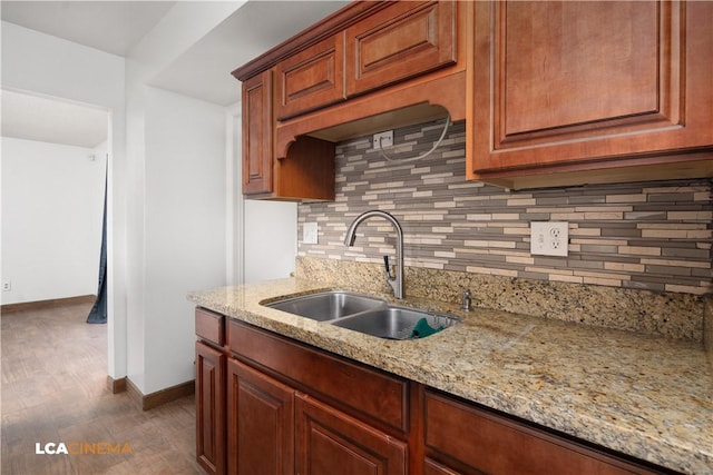 kitchen with sink, decorative backsplash, and light stone countertops