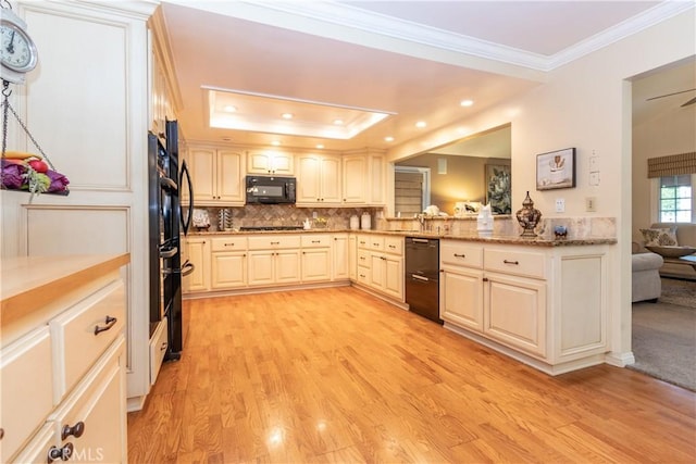 kitchen featuring tasteful backsplash, ornamental molding, light hardwood / wood-style floors, black appliances, and light stone countertops