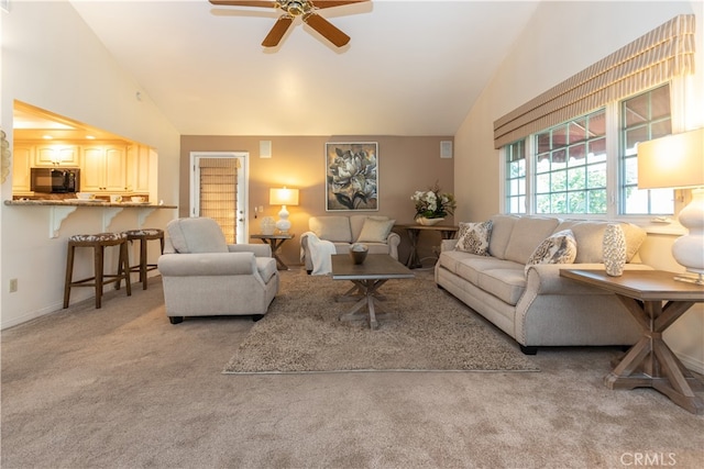 carpeted living room with vaulted ceiling and ceiling fan