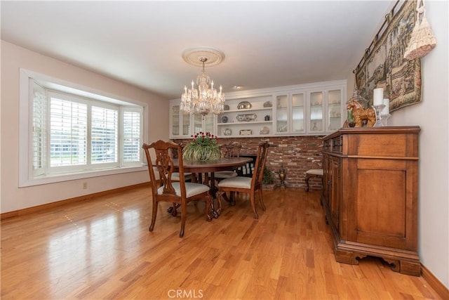 dining area with a notable chandelier and light hardwood / wood-style floors