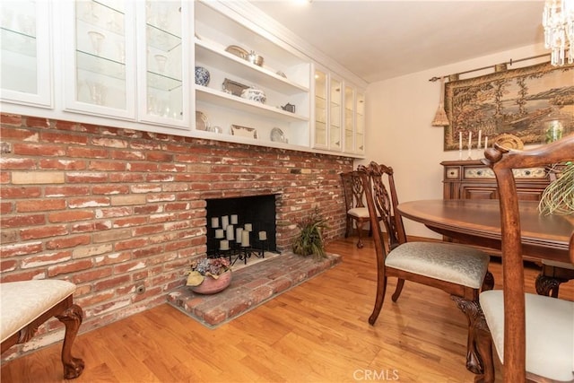 dining space featuring a fireplace and light hardwood / wood-style flooring