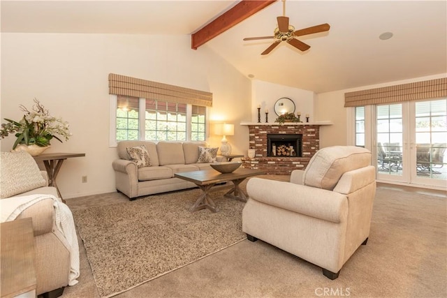 carpeted living room featuring a brick fireplace, a wealth of natural light, lofted ceiling with beams, and ceiling fan