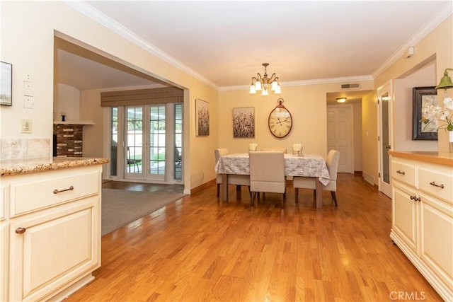 dining room with crown molding, a chandelier, and light wood-type flooring