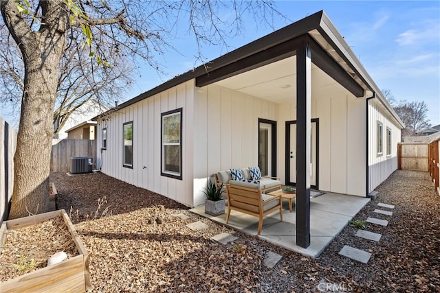 rear view of property with an outdoor living space, a patio area, and central air condition unit