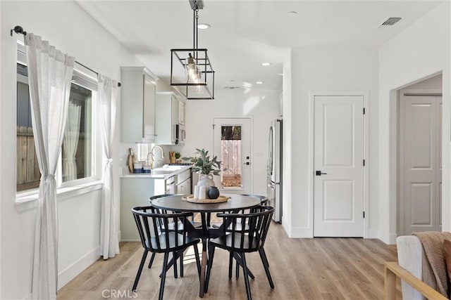 dining space with sink, a wealth of natural light, and light wood-type flooring