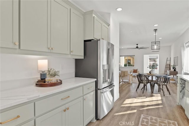 kitchen featuring pendant lighting, light stone countertops, stainless steel refrigerator with ice dispenser, and light wood-type flooring