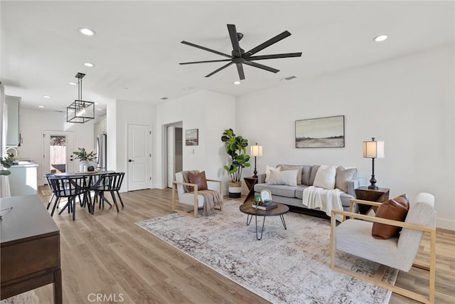 living room featuring light hardwood / wood-style floors and ceiling fan