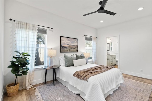 bedroom featuring connected bathroom, wood-type flooring, and ceiling fan