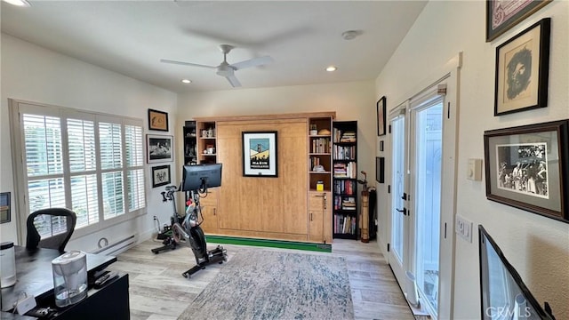 workout room featuring ceiling fan and light hardwood / wood-style flooring