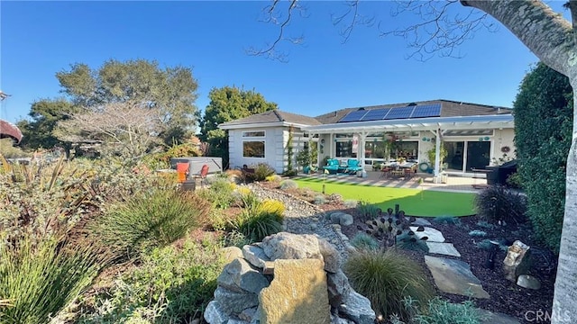 rear view of house with an outdoor living space, a patio area, and solar panels