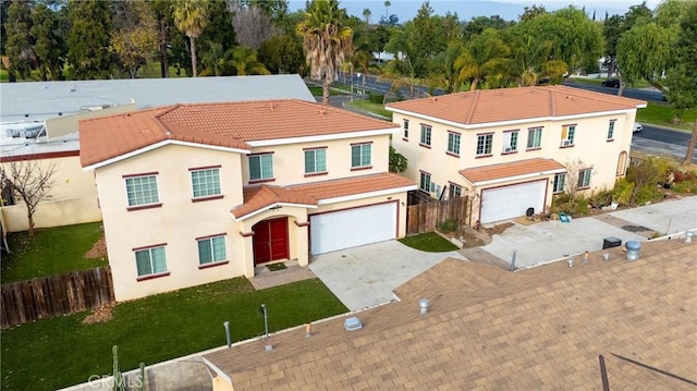 mediterranean / spanish home featuring a garage and a front lawn