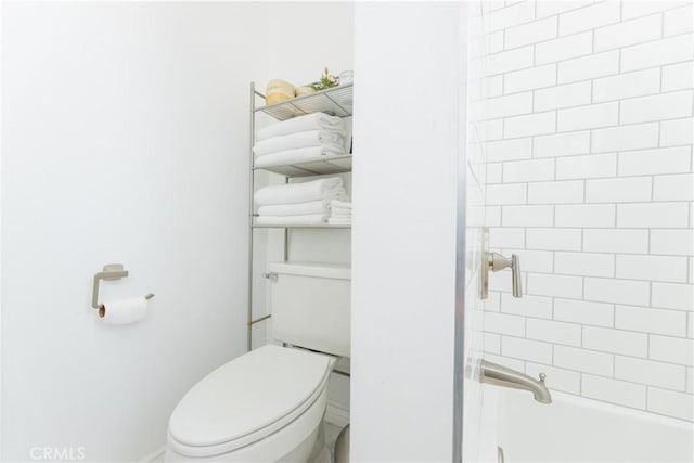 bathroom featuring tiled shower / bath and toilet