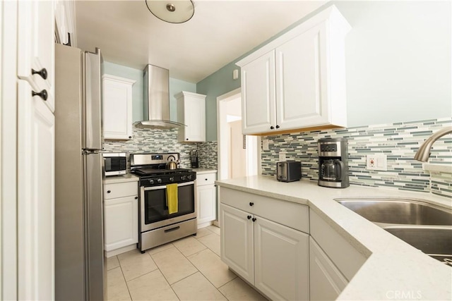 kitchen featuring white cabinets, stainless steel appliances, sink, and wall chimney exhaust hood