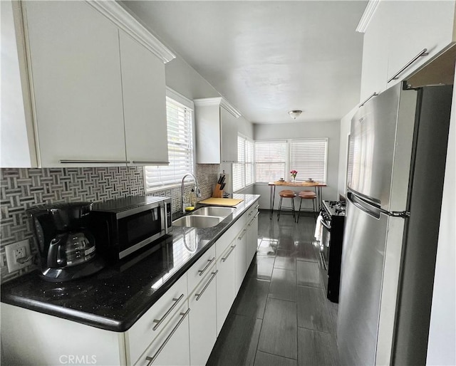 kitchen featuring white cabinetry, appliances with stainless steel finishes, sink, and decorative backsplash