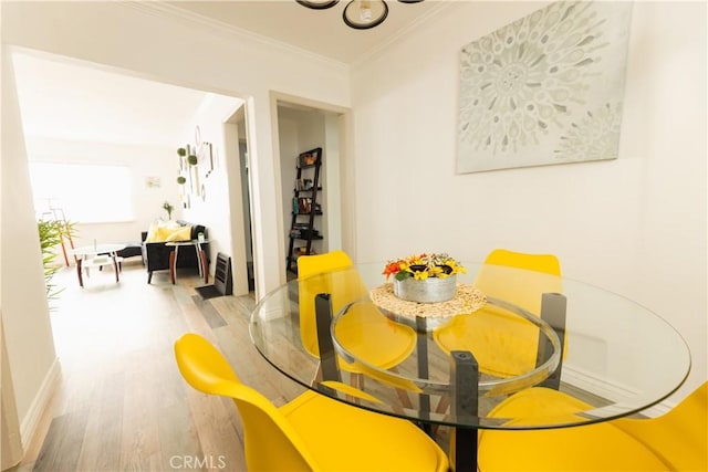 dining room featuring ornamental molding and light hardwood / wood-style floors