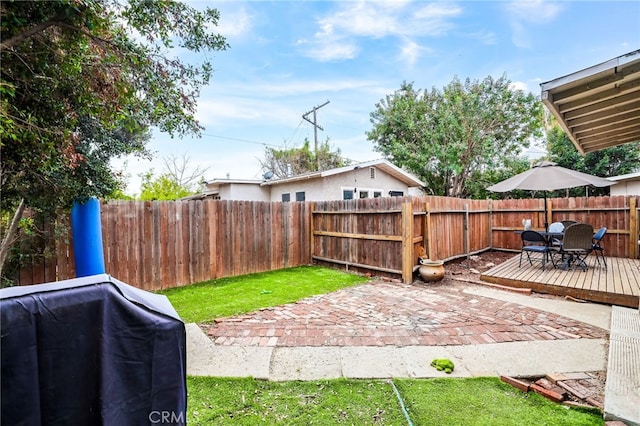 view of yard with a deck and a patio