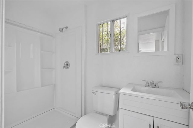 bathroom featuring vanity, a shower, and toilet