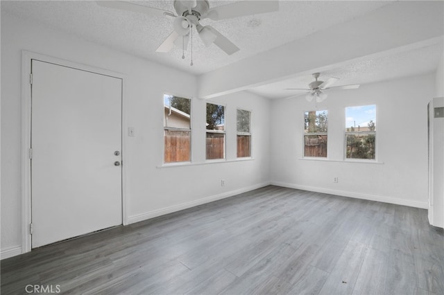 unfurnished room featuring ceiling fan, hardwood / wood-style floors, and a textured ceiling