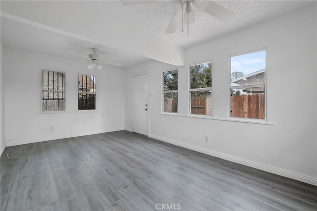 spare room featuring hardwood / wood-style flooring, ceiling fan, and a textured ceiling