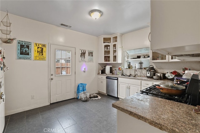 kitchen with sink, dark tile patterned floors, white cabinetry, stove, and stainless steel dishwasher